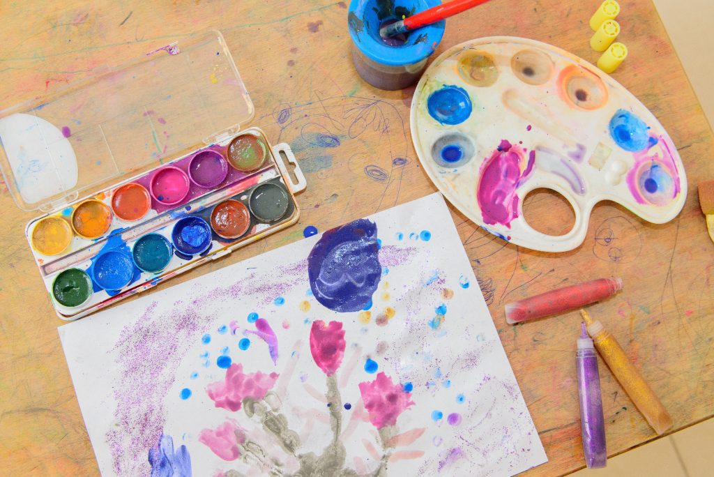 Watercolor paints, brushes and picture of flowers.