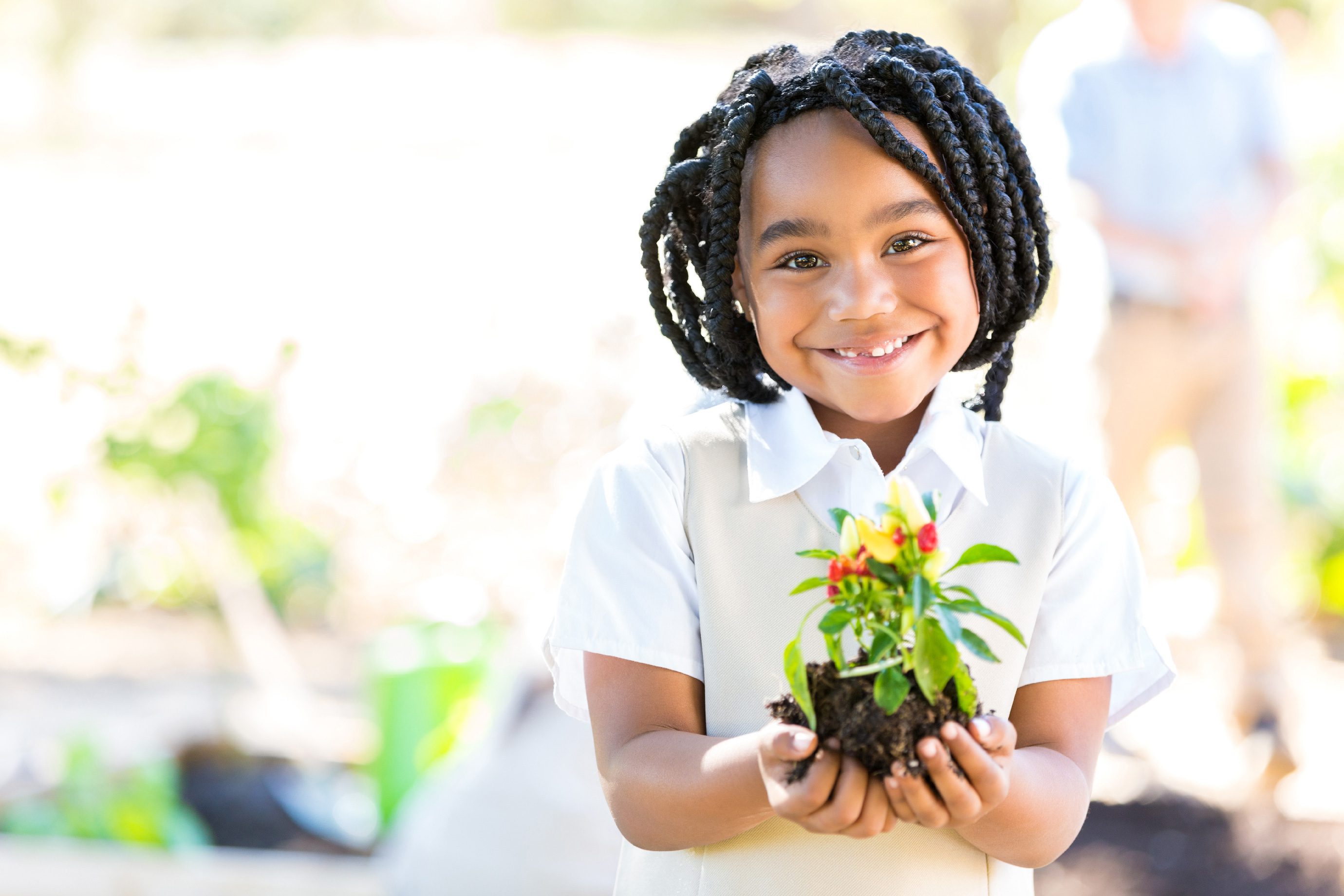 Student holding flower with both hands.